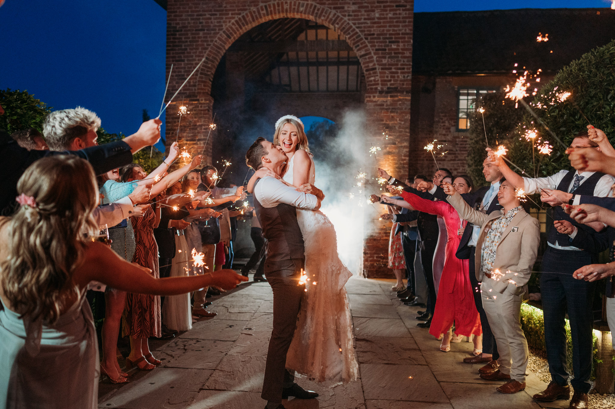 Groom picks up bride during sparkler tunnel at their Hazel Gap Barn Wedding